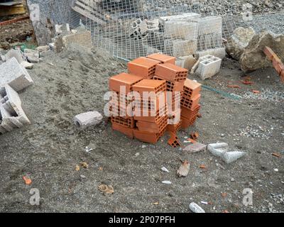 Building blocks on the ground. Material for the construction of warm houses. Progress. Construction from hollow concrete blocks. Stock Photo