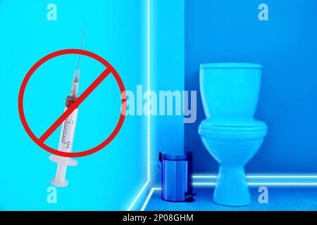 Toilet bowl in public restroom lit with UV blue light Stock Photo