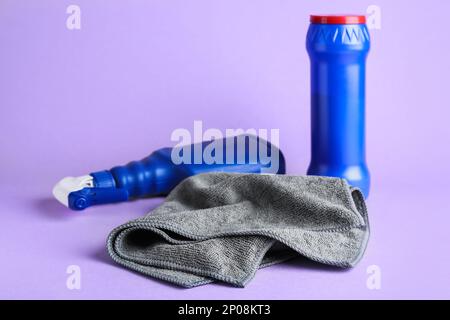 Grey microfiber cloth and detergents on light background Stock Photo