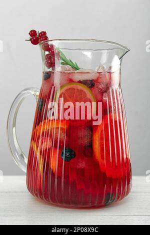 Glass jug of Red Sangria on white wooden table, closeup Stock Photo