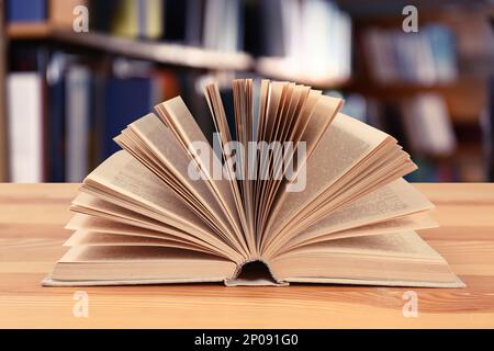 Open book on wooden table in library Stock Photo