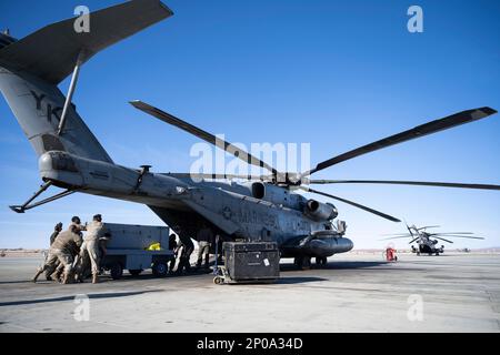 Airmen from the 9th and 29th Aircraft Maintenance Units load a hybrid flightline generator into a CH-53E Super Stallion at Marine Corps Air Ground Combat Command Center, Twentynine Palms, California, Feb. 16, 2023. Agile Combat Employment Reaper 23.6 saw Holloman Air Force Base Airmen being trained by Cannon AFB, N.M., Airmen on how to use a Portable Aircraft Control System. (U.S. Air Force photo by Staff Sgt. Kristin West) Stock Photo