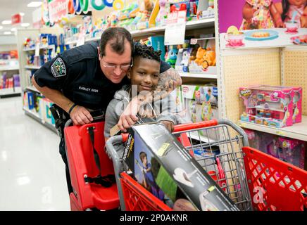 https://l450v.alamy.com/450v/2p0aknr/file-in-this-dec-15-2016-file-photo-austin-police-officer-david-easley-puts-a-tattooed-arm-around-jarvis-moblin-8-in-a-hug-during-the-14th-annual-shop-with-a-cop-shopping-spree-at-a-target-in-austin-texas-police-departments-compelled-by-a-hiring-crisis-and-eager-for-a-more-diverse-applicant-pool-are-relaxing-traditional-grooming-standards-and-getting-away-from-rules-that-used-to-require-a-uniformly-clean-shaven-1950s-look-more-officers-are-on-the-job-with-tattoos-inked-on-their-forearms-beards-on-their-chins-or-religious-head-coverings-like-hijabs-and-turbans-in-place-of-or-tuc-2p0aknr.jpg