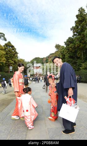 A traditionally dressed Japanese family walking into the Tsurugaoka Hachimangū Shrine in Kamakura, Japan. Stock Photo