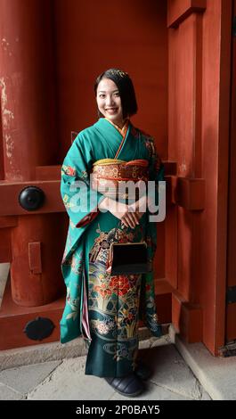 A young Japanese woman wearing a traditional Kimono at the Tsurugaoka Hachimangū Shinto shrine in Kamakura, Japan. Stock Photo