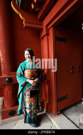 A young Japanese woman wearing a traditional Kimono at the Tsurugaoka Hachimangū Shinto shrine in Kamakura, Japan. Stock Photo