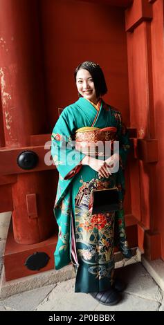 A young Japanese woman wearing a traditional Kimono at the Tsurugaoka Hachimangū Shinto shrine in Kamakura, Japan. Stock Photo