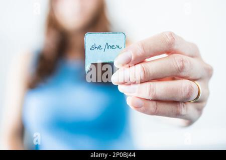 woman holding gender identity pronouns She Her on paper speech bubble, concept of respecting people's identity in society Stock Photo