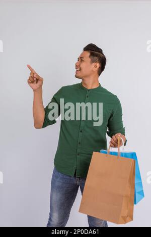 asian man looking at his right side and pointing with his finger Stock Photo
