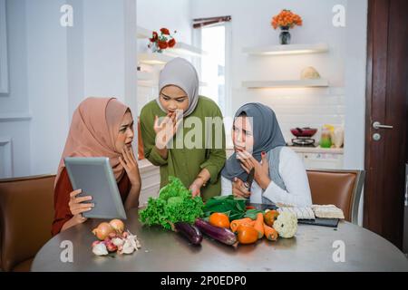 Hijab women and friends using tablet smartphone and shocked Stock Photo