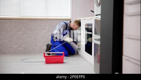 Plumber Drain Cleaning Services In Kitchen. Unclog Blocked Pipe Stock Photo