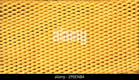 Yellow EPE fruit net abstract close-up background. Expanded polyethylene foam net macro texture Stock Photo