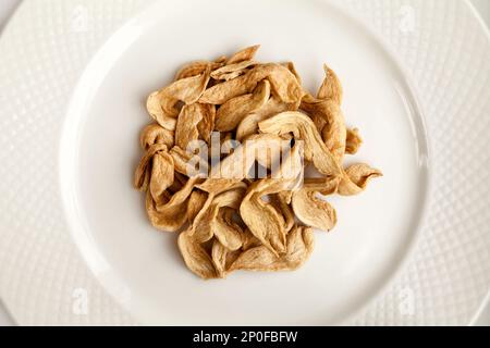 Small pile of raw soy meat slices on a plate top view. Some soybean meat  uncooked slices on a white background Stock Photo