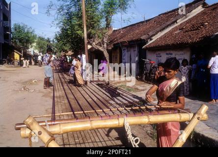 Old tradition practiced by weavers, removing knots and drying silk yarn on the street of Pillaiyarpalayam, Kanchipuram, Tamil Nadu, India Stock Photo