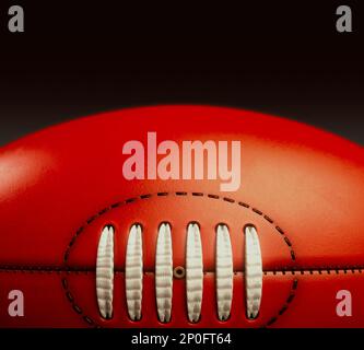 A generic unbranded aussie rules football ball on an isolated dark studio background - 3D render Stock Photo