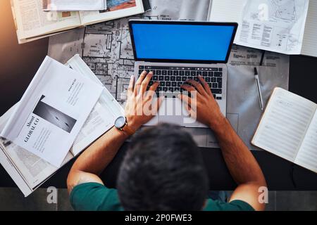 Hands, laptop and overhead with an architect man at his desk, working on design or a building plan. Computer, architecture and blueprint with a male Stock Photo