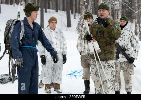 A Finnish winter survival instructor assigned to Jaeger Brigade, instructs a group of Finnish conscripts and U.S. Army Soldiers assigned to Charlie Company, 1-24 Infantry Battalion, 11th Airborne Division on how to properly plunge into the water during winter survival training at Arctic Forge 2023 on Sodankylä Garrison, Finland, Feb 19, 2023. Exercise Arctic Forge 23 is a U.S. Army Europe and Africa led umbrella exercise that leverages the host nation exercises Defense Exercise North in Finland, and exercise Joint Viking in Norway, taking place Feb. 16 through March 17, 2023, focused on buildi Stock Photo