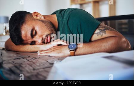 Tired, burnout and man sleeping on a desk after studying, education or stress from remote work. Lazy, nap and student with fatigue, sleep and resting Stock Photo