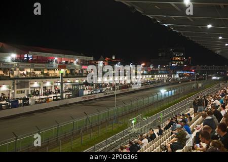 Nuerburgring, race track at night, grandstand with spectators, race cars, racing, night view, Eifel, Rhineland-Palatine, Germany Stock Photo