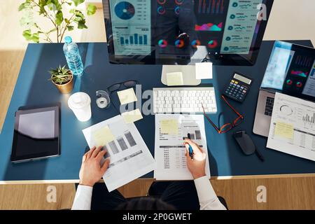 Businessman entrepreneur working with data on charts and graphs on computer screen. Man using computer and laptop working with documents sitting at de Stock Photo