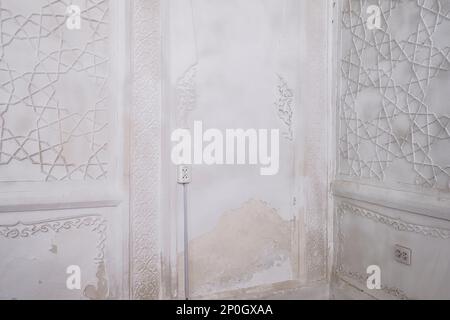 Close up, detail of the once colorful wall designs, now whitewashed. At an old, historic, classic, traditional, typical, iconic Jewish house in Bukhar Stock Photo