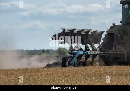 Agricultural tractor plowing a field before sowing. Stock Photo