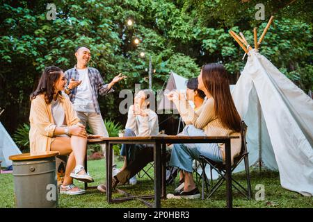 woman in cardigan sitting and pointing on her friend Stock Photo