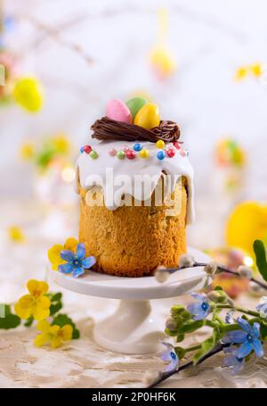 Traditional Easter Cake with chocolate nest and easter eggs candy. Easter treats with spring flowers decorations Stock Photo