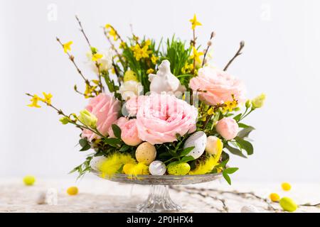 Easter still life with festive Flower composition. Spring flowers, tree branches,green grass, Easter eggs and decorations. Stock Photo