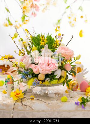 Easter still life with Flower composition and Traditional Easter treat on festive table decorated with spring flowers. Easter table. Stock Photo