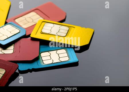 Different SIM cards on grey background, closeup Stock Photo