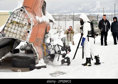 (Left to right) Duncan Hutchinson, firefighter, and Senior Airman Dustin Fahlbusch, fire protection journeyman, both with 775th Civil Engineering Squadron Fire Department, practice emergency engine shutdown procedures on a salvaged aircraft Jan. 25, 2023, at Hill Air Force Base, Utah. This was one of several scenarios practiced during an emergency responder working group exercise attended by first responders from across the Air Force to explore emergency engine shutdown and aircrew extraction best practices specific to F-35 aircraft. Stock Photo