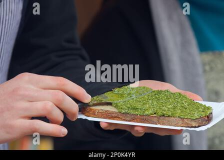 Making herb toasts at farmers street food market in Prague, Czech republic, cold winter day. Stock Photo