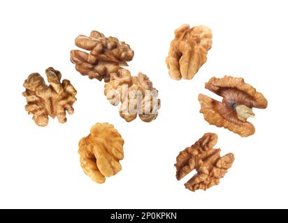 Halves of walnuts falling on white background Stock Photo