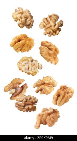 Halves of walnuts falling on white background Stock Photo