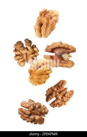 Halves of walnuts falling on white background Stock Photo