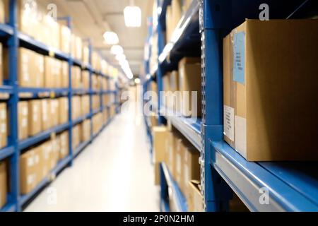 Row of packages and boxes inside a distribution warehouse with selective focus on the foreground Stock Photo