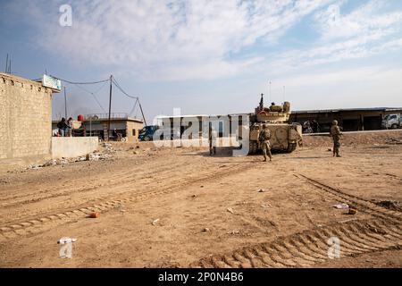 An M2A2 Bradley Fighting Vehicle, assigned to Charlie Company, 2nd Battalion, 116th Cavalry Regiment, Idaho National Guard, Combined Joint Task Force - Operation Inherent Resolve, parks near a market, Syria, Jan. 26, 2023. Stock Photo