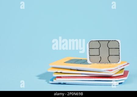 Different SIM cards on light blue background. Space for text Stock Photo