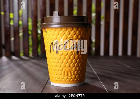 MYKOLAIV, UKRAINE - AUGUST 12, 2021: Hot McDonald's drink on wooden table Stock Photo