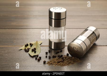 https://l450v.alamy.com/450v/2p0neet/salt-and-pepper-shakers-with-bay-leaves-on-wooden-table-closeup-2p0neet.jpg