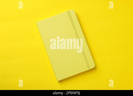 New stylish planner with hard cover on yellow background, top view Stock Photo
