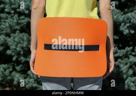 Woman with foam tourist seat mat outdoors, closeup Stock Photo