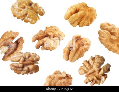 Halves of walnuts falling on white background Stock Photo