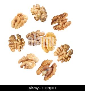 Halves of walnuts falling on white background Stock Photo
