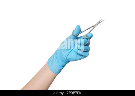 Manicure, nail scissors in hand with blue glove. Hand holding scissors for manicure isolated on white background. Stock Photo