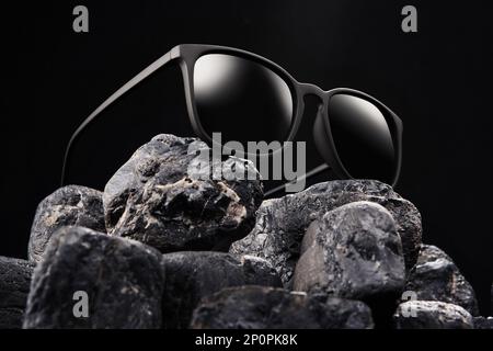 Open sunglasses, sun shades in plastic frame is on stones Stock