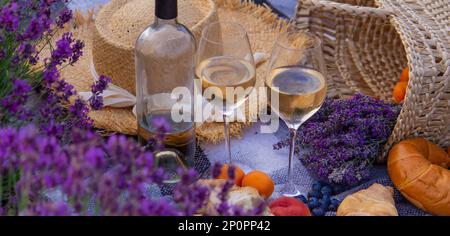 wine, fruits, berries, cheese, glasses picnic in lavender field Selective focus Nature Stock Photo