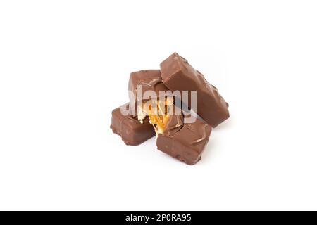 Hazelnuts and caramel cream chocolate bars stacked, isolated on white background Stock Photo