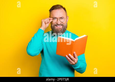 Photo portrait of attractive grandpa touch specs read writing notes professor dressed stylish cyan look isolated on yellow color background Stock Photo